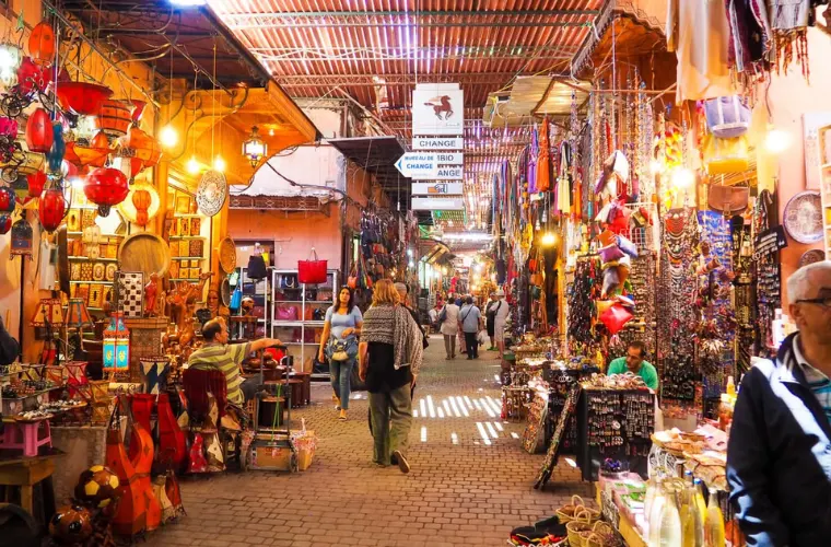 Colorful Marrakech medina souk with traditional lanterns, handicrafts, and souvenirs in narrow alleyway